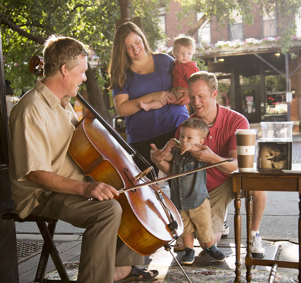 Photo of a family listening to a street musician in Omaha's Old Market