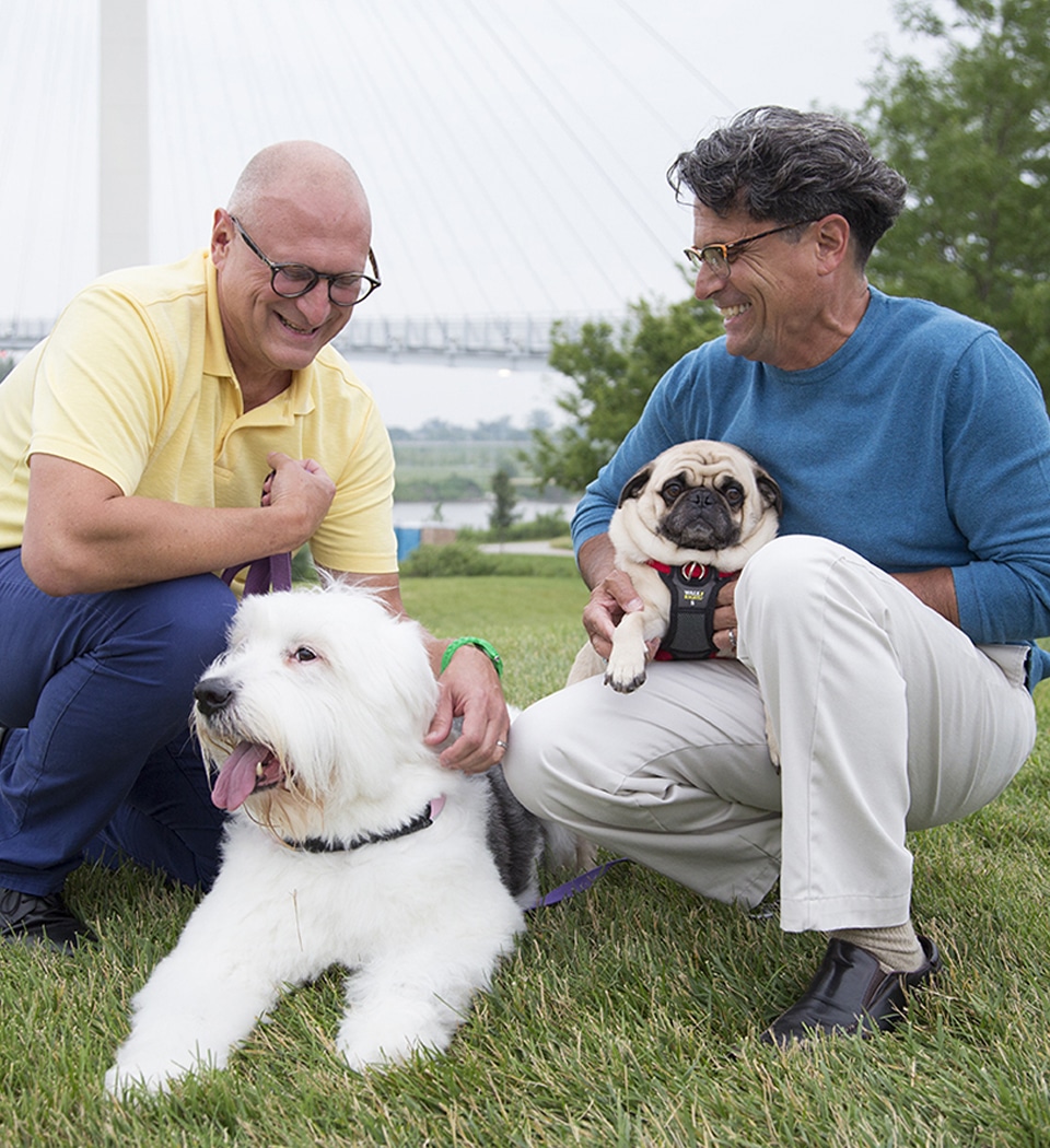 Photo of two older men with their dogs in a park