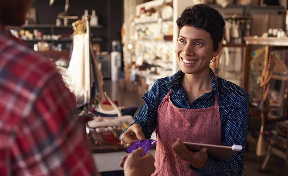 Photo of a business owner handing a customer back their Centris credit card