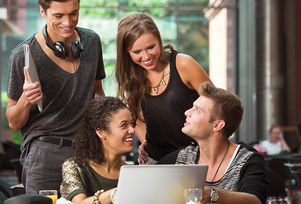 Photo of college students gathered around a laptop