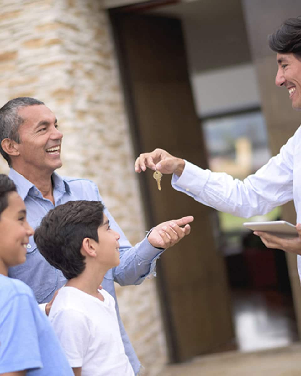 Photo of a family receiving keys to their new home