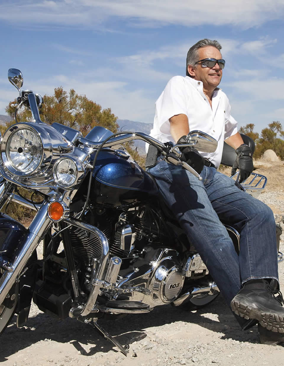 Photo of a man leaning against his motorcycle