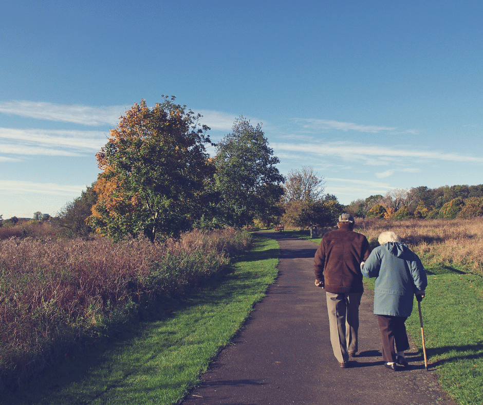 Older couple walking outside.