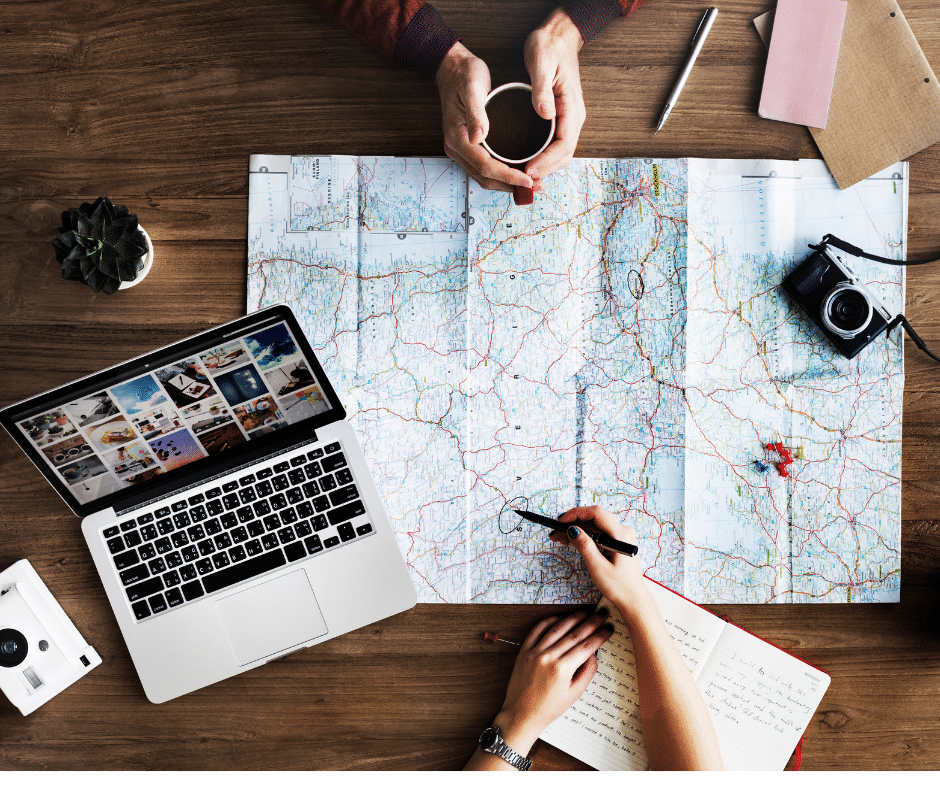 People planning a vacation with a map and laptop