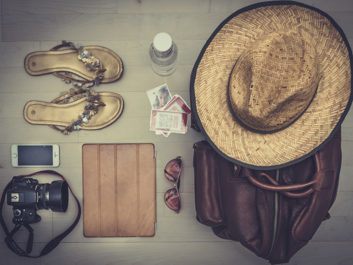 Travel items flip flops, hat, camera, ipad, phone