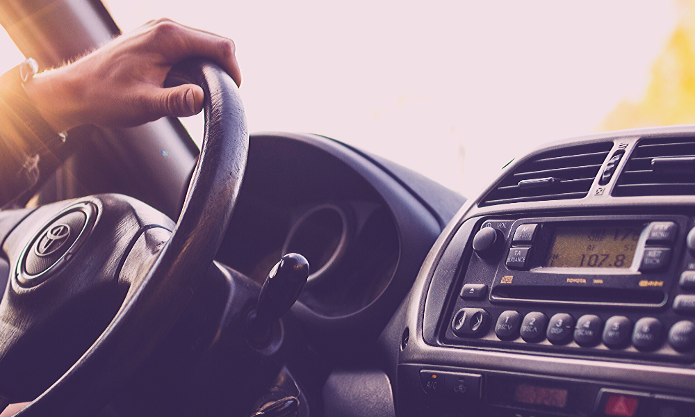Man holding a car steering wheel